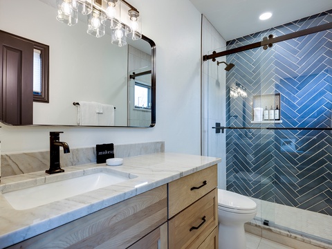 Refresh in your private spa-like bathroom, where elegant herringbone tile and modern fixtures create a serene retreat after days of adventure.