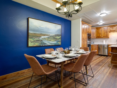 Picture yourself enjoying meals around this inviting dining table, with a fully equipped kitchen at your fingertips. The rich wood tones and bold blue accent wall create a warm, stylish retreat for your mountain getaway.