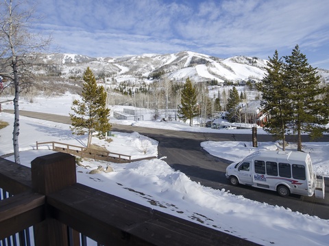Winter wonderland featuring snow-capped mountains, evergreen forest, and convenient shuttle service accessing the ski slopes and surrounding alpine area.