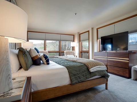 Sink into plush bedding with mountain views framing your stay. Thoughtful furnishings and natural light create your perfect retreat.