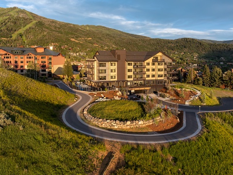 Nestled at the base of a forested mountain range, this alpine resort offers a scenic arrival through landscaped roundabout gardens with peak views in every direction.
