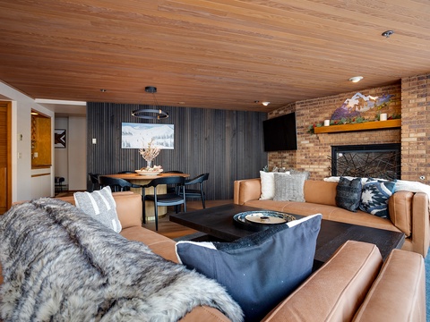 Unwind in this inviting living space where rich leather seating, a cozy fireplace, and warm wood accents create the perfect mountain retreat for your après-ski relaxation.