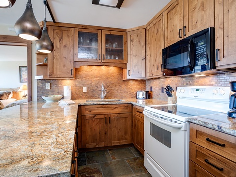 Craft your favorite meals in this fully-equipped kitchen with rich wood cabinetry, granite countertops, and modern appliances—perfect for cozy mornings or gathering with loved ones.