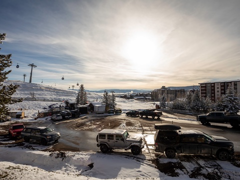 Ski-in convenience with snowy slopes, gondola access, and mountain village setting framed by a stunning winter sunrise.