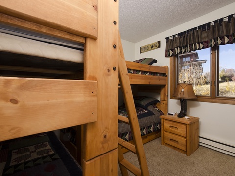 Cozy bunk room with twin beds and charming mountain views—perfect for kids or extra guests to rest after a day of adventure.