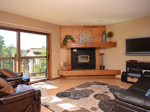 Unwind in your spacious living room, where sunlight streams through the balcony doors and a cozy fireplace invites you to relax after a day of adventure.