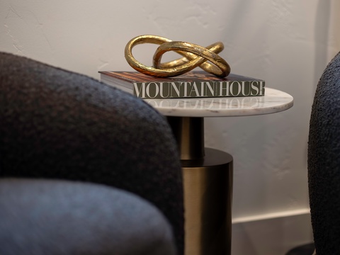 A golden sculpture and stylish side table add elegant touches to your seating area, creating a sophisticated space to unwind.