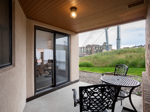 Private covered patio overlooking green open space and neighborhood views, perfect for enjoying morning coffee or evening relaxation in your outdoor retreat.