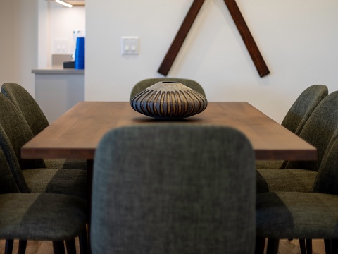 Gather around this handsome wooden dining table for memorable meals and conversations. Modern chairs and thoughtful decor create an inviting space where your group can connect.