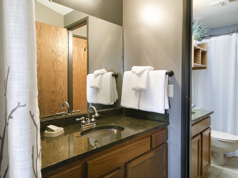 Your bathroom features fresh towels, warm wood tones, and modern fixtures—everything you need to feel instantly at home and refreshed.