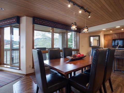 Gather around this elegant dining table with waterfront views streaming through floor-to-ceiling windows, where your meals are framed by serene lake scenery and natural light.