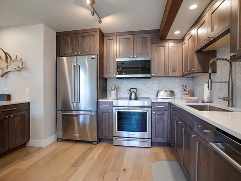 Your gourmet kitchen features stainless steel appliances, sleek countertops, and rich wood cabinetry, perfect for preparing memorable meals during your mountain escape.