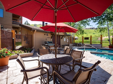 Relax poolside under vibrant red umbrellas, surrounded by rolling green hills and mountain views. Your own outdoor oasis awaits, complete with a hot tub, grill, and inviting patio seating.