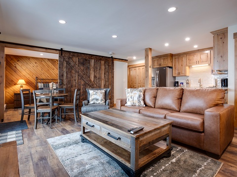Unwind in your open-concept space with rustic sliding barn door, cozy leather seating, and warm wood details that bring mountain charm home.