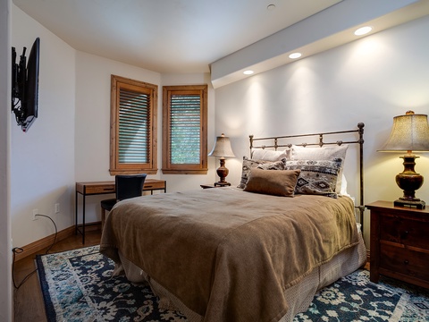Sink into plush linens and drift off in your cozy bedroom, styled with warm wood tones, elegant lighting, and soft textures for ultimate comfort.
