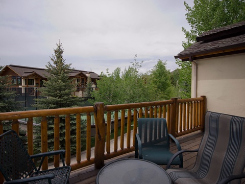 Step out onto your private balcony and breathe in the fresh mountain air. Relax in comfortable seating surrounded by tall pines and peaceful greenery—your perfect retreat awaits.