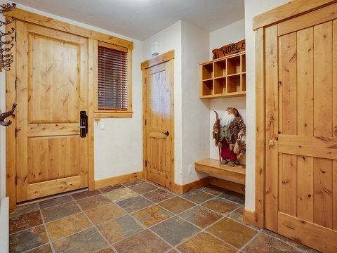 Step inside to rustic charm with warm knotty pine doors, slate tile floors, and thoughtful storage—a welcoming mudroom designed for your mountain getaway.
