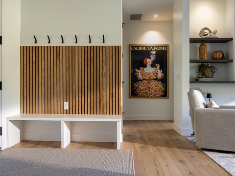 This welcoming entryway features a built-in bench with coat hooks, offering you the perfect spot to transition from outdoor adventures to indoor comfort.