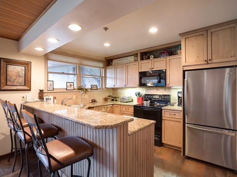 Your fully-equipped kitchen features granite countertops, stainless steel appliances, and a breakfast bar where you can savor morning coffee or prepare home-cooked meals during your mountain getaway.