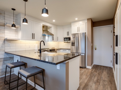 Your modern kitchen awaits with gleaming granite counters, stainless steel appliances, and a breakfast bar perfect for morning coffee or casual meals.
