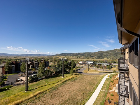 The property sits in a scenic mountain community with rolling hills and open vistas stretching toward distant peaks, creating a peaceful natural setting for your stay.