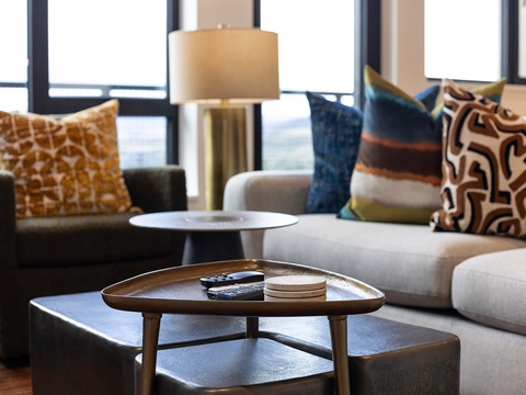 Sink into plush seating with vibrant throw pillows as natural light pours through expansive windows, creating your perfect space to unwind after exploring the city.