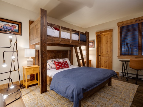 Your cozy mountain retreat features custom bunk beds with rich wood finishes, perfect for families. Warm lighting and rustic touches create a welcoming atmosphere for restful nights.