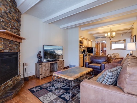 Relax in your inviting living space with rich leather seating, a warm stone fireplace, and an open flow to the fully equipped kitchen—your perfect home away from home.