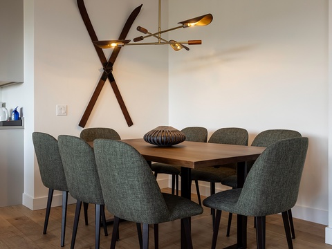 Gather around the stylish dining table where shared meals become cherished memories. The modern chandelier and unique wall art create a welcoming atmosphere for your group.