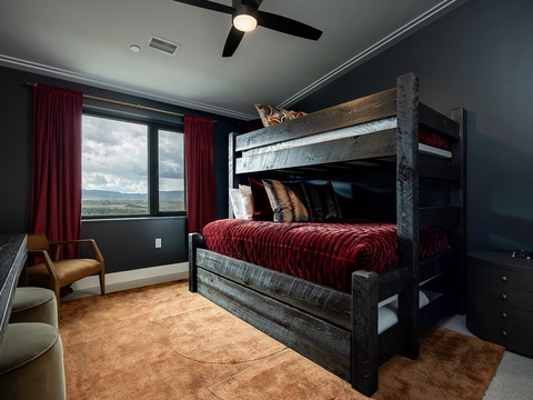 Your little ones will love claiming the top bunk in this bold, cozy bedroom with sweeping views through the window. Plush bedding and a ceiling fan create restful comfort for a good night's sleep.