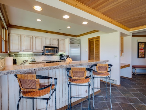 Picture yourself preparing meals in this bright, fully equipped kitchen with modern appliances, granite counters, and an inviting breakfast bar where you can enjoy morning coffee or casual dining with your group.