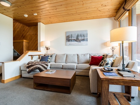 Sink into the plush sectional sofa and let the warm wood tones and soft lighting melt away your worries. Your perfect mountain escape awaits in this inviting living space.