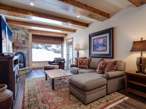 Curl up in your inviting living room where rustic wood beams meet cozy comfort. Warm lighting, plush seating, and a crackling fireplace create the perfect retreat after a day of adventure.
