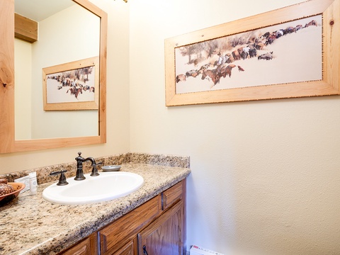 Refresh in your private bathroom featuring a granite countertop, wooden vanity, and charming wildlife artwork that brings a touch of nature indoors.