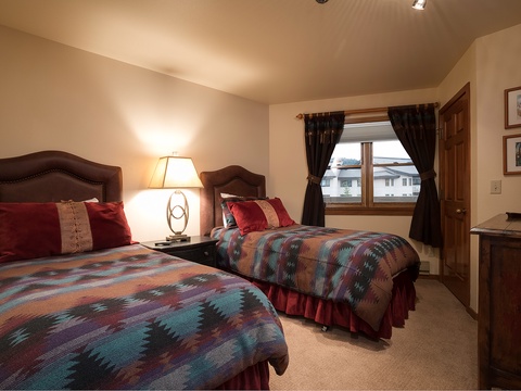 Settle into your cozy twin bedroom with mountain views and soft lighting for a peaceful night's rest.