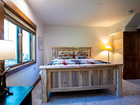 Unwind in your private bedroom featuring a rustic wood bed, warm ambient lighting, and mountain-inspired décor that invites restful nights after your adventures.