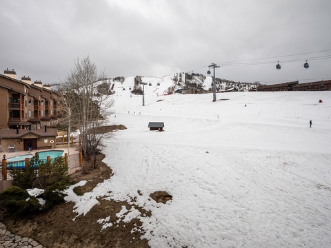 Snow-covered ski slopes with gondola access adjacent to the property, featuring an outdoor pool and mountain resort lodging in a scenic winter destination.
