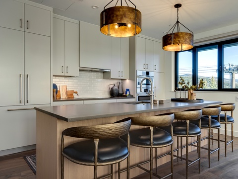 Gather around the sleek island in your gourmet kitchen, where contemporary design meets mountain vistas—perfect for morning coffee or evening drinks with friends.