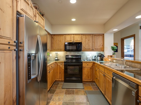 Your fully equipped kitchen features stainless steel appliances, warm wood cabinetry, ample counter space, and everything you need to prepare meals just the way you like them.