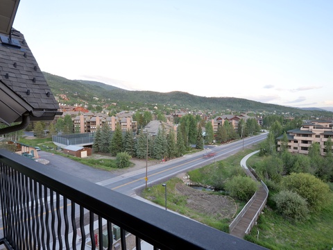 A peaceful mountain town setting with residential buildings nestled among evergreens, offering a scenic backdrop of forested slopes and quiet streets.