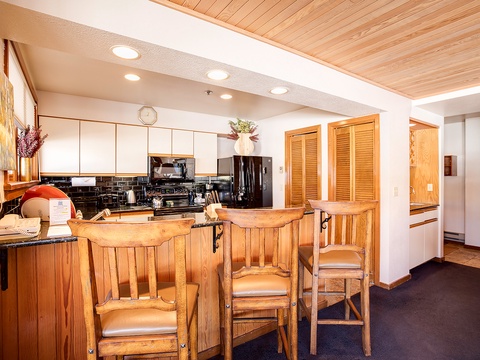 Picture yourself cooking in this fully equipped kitchen with black granite counters, modern appliances, and warm wood accents—complete with a convenient breakfast bar for casual meals.