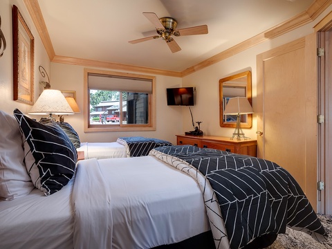 Slip into crisp linens and sink into comfort in this thoughtfully designed guest room, complete with ceiling fan and TV for your perfect retreat.