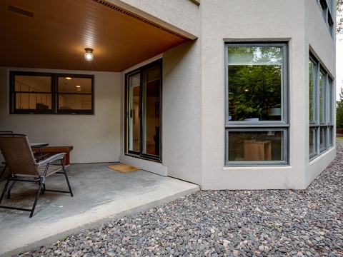 Modern stucco exterior with clean architectural lines, large windows letting in natural light, and a covered patio entry perfect for relaxing outdoors after exploring the area.