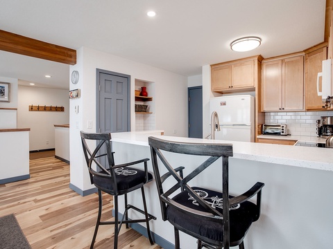 Your bright, open-concept kitchen invites you to gather around the breakfast bar, complete with modern appliances and warm wood cabinetry for preparing and sharing meals together.