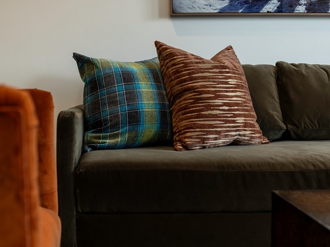 Settle in on plush velvet sofas with textured throw pillows, where every detail is designed for your comfort and relaxation.