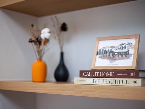 A cozy shelf display with curated books and decor sets a welcoming, lived-in tone for your stay.