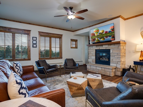 Sink into the plush leather seating and unwind by the warmth of the stone fireplace. Large windows frame mountain views while modern comforts and thoughtful décor create your perfect retreat.