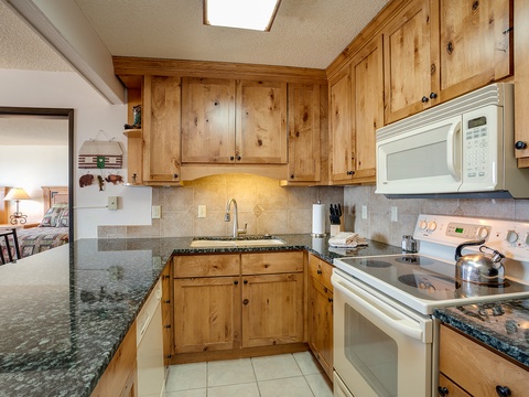 Your fully equipped kitchen features warm knotty pine cabinetry, granite counters, stainless steel appliances, and everything you need to prepare meals during your stay.