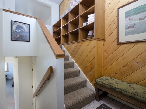 A welcoming entryway with warm wood accents and organized storage leads you upstairs. Cozy bench seating and thoughtful design make your arrival feel like coming home.