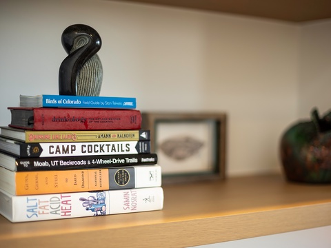 A carefully curated collection of adventure guides, field manuals, and cocktail recipes sits ready to inspire your next outdoor escape or cozy evening in.